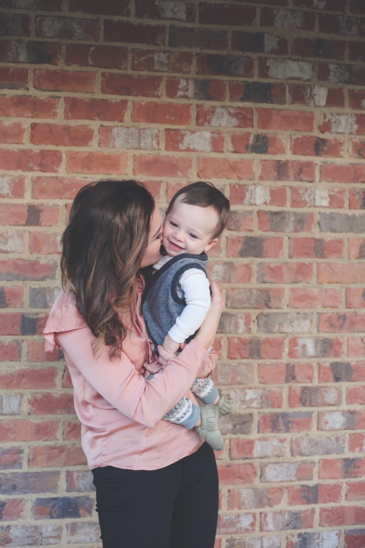 Mom and Baby pink style // Valentine's Day Mom & Baby Outfit // Valentine's Day Mom Outfit from Heather of MyLifeWellLoved.com Baby Boy and Mom Fashion | Cute Valentine's Day Outfits for Mom & Baby featured by top life and style blog, My Life Well Loved: image of a woman wearing a TOPSHOP ruffle tee, TOPSHOP skinny jeans, Rag & bone leather booties. Baby wears a Tea boy tee shirt, H&M vest and Freshly Picked moccs.