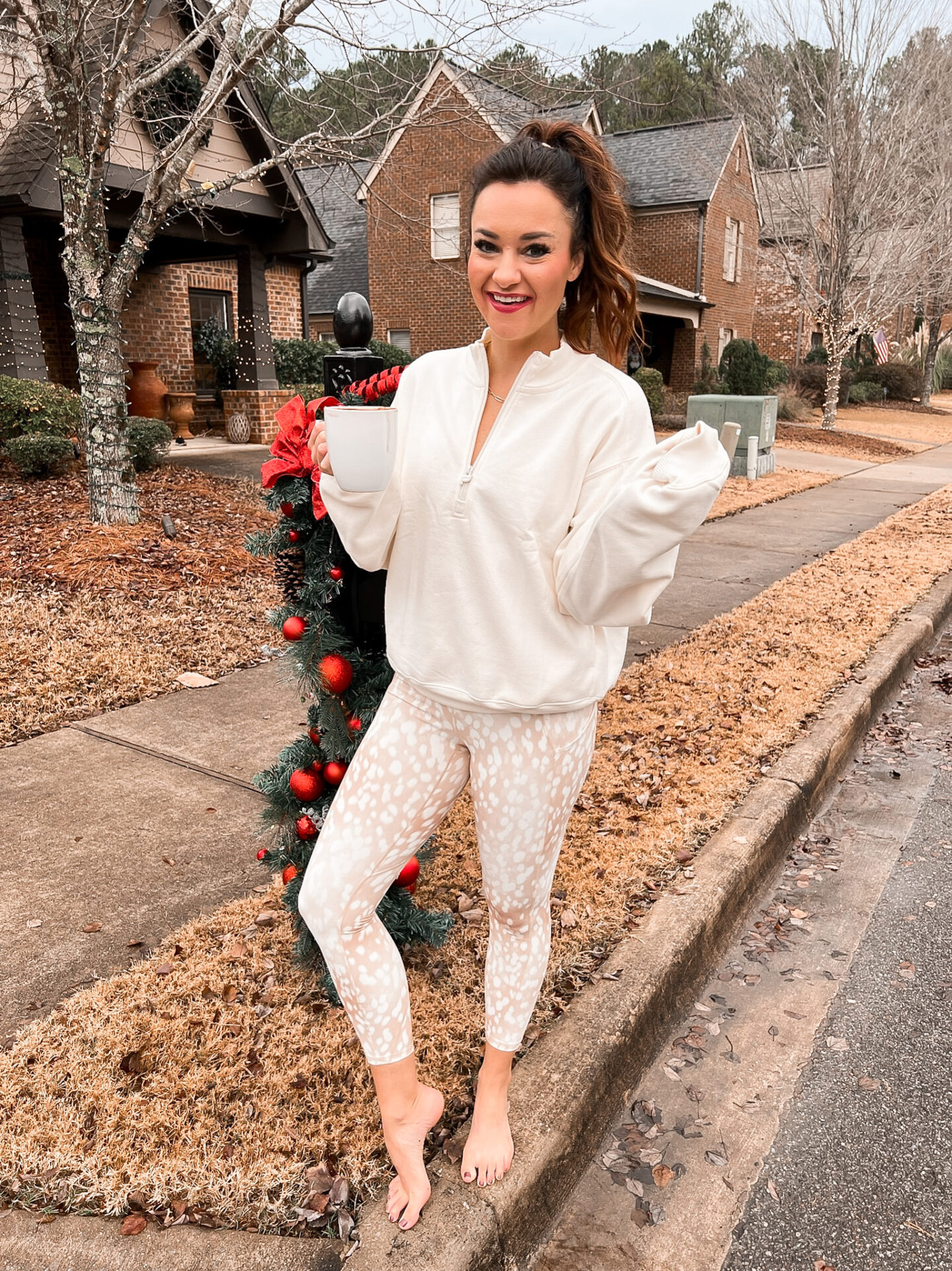 Heather poses in Fabletics athletic clothing beside holiday decor  